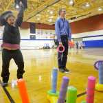 Jordan Tackett (left) reacts after beating occupational therapist Matt Jager in a ring-toss game during the Autism Extravaganza awareness fair at Soldotna Preparatory School on Saturday, April 4. Tackett, who is autistic, was among those who came to play games and socialize during the event.