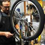 Photo by Elizabeth Earl/Peninsula Clarion Brad Carver, a mechanic at Beemun's Bike and Ski Loft in Soldotna, trues the front wheel of a bike during a spring tune-up on Tuesday, March 29, 2016.