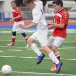 Photo by Jeff Helminiak/Peninsula Clarion Soldotna's Timmy Smithwick protects the ball from Kenai Central's Max Dye on Thursday, April 14, 2016, at Soldotna High School.