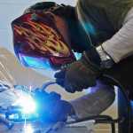 Photo by Elizabeth Earl/Peninsula Clarion Cam Choy, an associate professor of art at Kenai Peninsula College, welds the steel frame of what will be a 12-foot sculpture of a sockeye salmon in the college's 3D design studio on Friday, April 15, 2016.