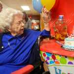Photo by Megan Pacer/Peninsula Clarion Hazel George opens a present prepares to eat her cake during a birthday party Sunday, April 24, 2016 at Heritage Place in Soldotna, Alaska. George joined the other centenarians in the state when she turned 100 Sunday.
