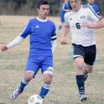 Photo by Jeff Helminiak/Peninsula Clarion Kodiak's Daniel Beltran gets rid of the ball as Nikiski's Nathan Carstens closes in Tuesday at Nikiski High School.