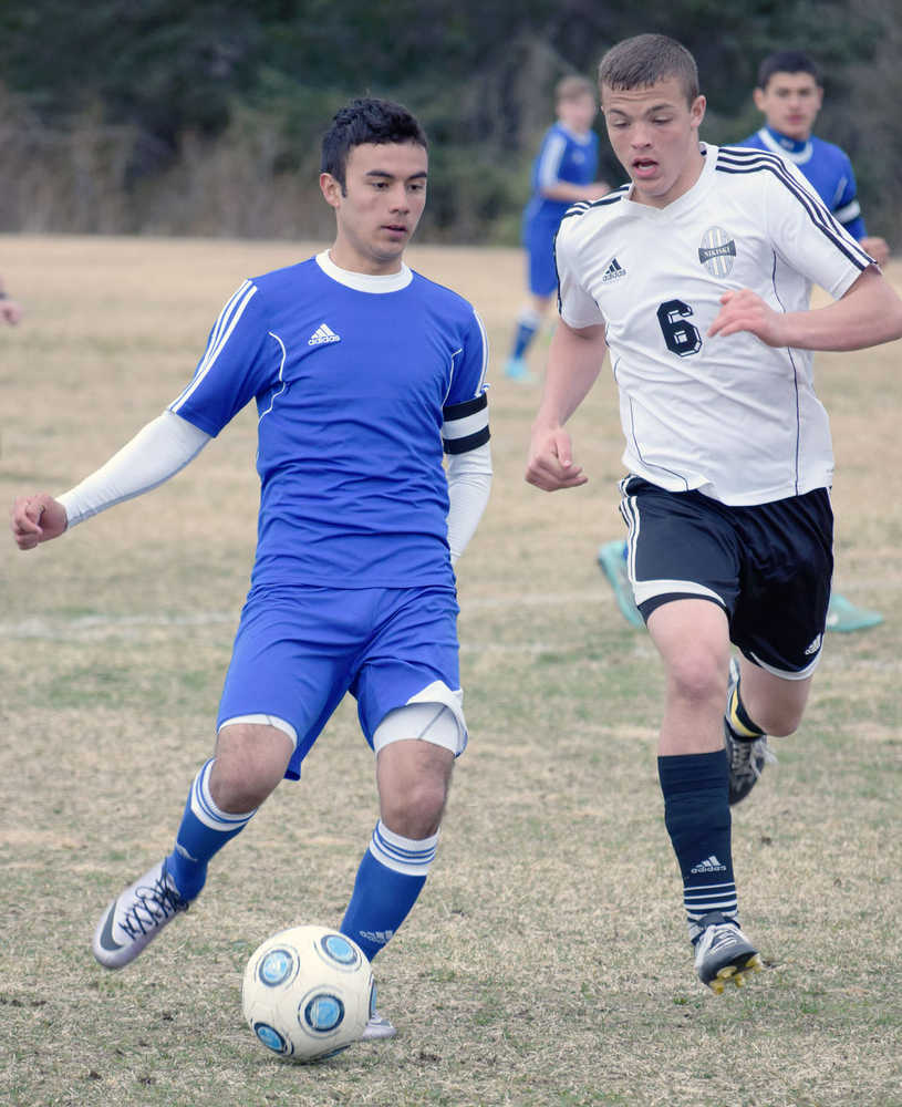 Photo by Jeff Helminiak/Peninsula Clarion Kodiak's Daniel Beltran gets rid of the ball as Nikiski's Nathan Carstens closes in Tuesday at Nikiski High School.