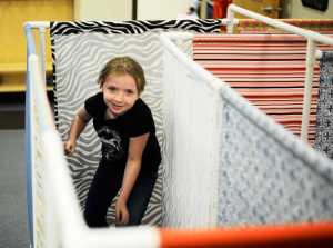 Brynnen Hanson runs through a maze of cloth panels at AK Kids Early Learning Center on Saturday, April 30 in Kenai.