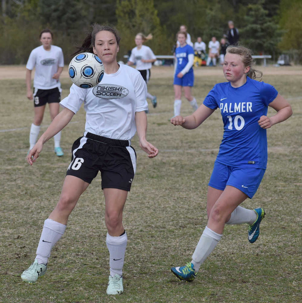 Photo by Joey Klecka/Peninsula Clarion Nikiski's Rylee Jackson eyes the airborne ball with Palmer's Anahelena Taylor (10) closing in Friday at Nikiski High School.