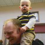 Photo by Megan Pacer/Peninsula Clarion Darren Finley carries his son, 15-month-old Maximus, after his graduation ceremony Thursday, May 5, 2016 in the Renee C. Henderson Auditorium at Kenai Central High School in Kenai, Alaska. Finley graduated Kenai Peninsula College's paramedic technology program and has been employed with Central Emergency Services since November 2015.