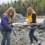 Redoubt students walk the banks of the Kenai River picking up large and small trash.