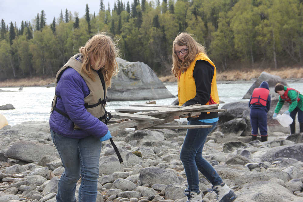 Redoubt students walk the banks of the Kenai River picking up large and small trash.