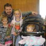 Rotarian Evan Frisk and his girls pick up their Rotary Roses.