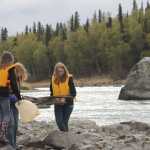 Redoubt students walk the banks of the Kenai River picking up large and small trash.