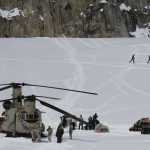 This photo taken Sunday, April 24, 2016, on the Kahiltna Glacier in Alaska, shows Army soldiers unloading a Chinook helicopter that landed on the glacier near Denali. The U.S. Army helped set up base camp on North America's tallest mountain. Three Chinook helicopters the size of city buses took supplies like food, communication equipment and fuel to the base camp at the 7,200-foot level of Denali.  (AP Photo/Mark Thiessen)