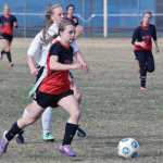 Photo by Jeff Helminiak/Peninsula Clarion Kenai Central's Hayley Maw races out ahead of Nikiski's Daisy Schwenke on Monday at Nikiski High School.