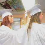 Photo by Megan Pacer/Peninsula Clarion Richele McGahan adjusts the pins in Victoria Cizek's hair moments before they joined their two fellow senior classmates to walk into their graduation ceremony Sunday, May 8, 2016 at Cook Inlet Academy in Soldotna, Alaska. The school had a smaller graduating class than usual, with only four high school seniors.