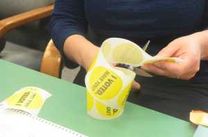 Photo by Megan Pacer/Peninsula Clarion Election Board member Kim Macdonald cuts out enough stickers to keep up with voters during a special election Tuesday, May 10, 2016 at Soldotna City Hall in Soldotna, Alaska. The election held to decide if the city would form a charter commission saw a steady stream of voters during lunchtime hours.