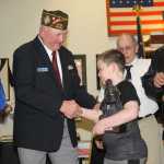 George Walters presents Haedyn with a miniature replica of the Iron Mike statue soon to be erected at Soldotna Creek Park.