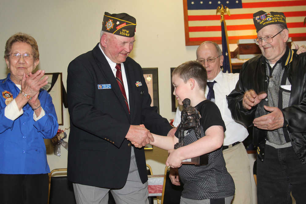 George Walters presents Haedyn with a miniature replica of the Iron Mike statue soon to be erected at Soldotna Creek Park.