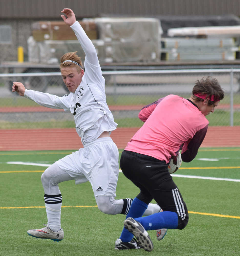 Photo by Joey Klecka/Peninsula Clarion Soldotna midfielder Rykker Riddall nearly collides with Kodiak goalkeeper Matt Schauff, Friday at Ed Hollier Field in Kenai.