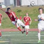 Photo by Joey Klecka/Peninsula Clarion Kenai Central midfielder Kevin Ramos (center) sends the ball downfield in Friday's state soccer semifinal against Service at Service High School.