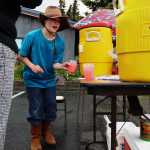 Michael Dominic pours two glasses of pink lemonade for a customer at his stand outside Charlotte's Cafe on Saturday, June 11 in Kenai.