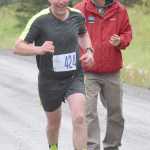 Photo by Joey Klecka/Peninsula Clarion Soldotna runner Carl Kincaid (424) receives encouragement from a course worker in Saturday's men's 5K Run for the River race in Soldotna.