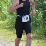Photo by Jeff Helminiak/Peninsula Clarion Jenny Kimball of Anchorage nears the finish of the 5-kilometer run and the finish line Sunday at Tri the Kenai at Tsalteshi Trails. Kimball won the women's Sprint division.