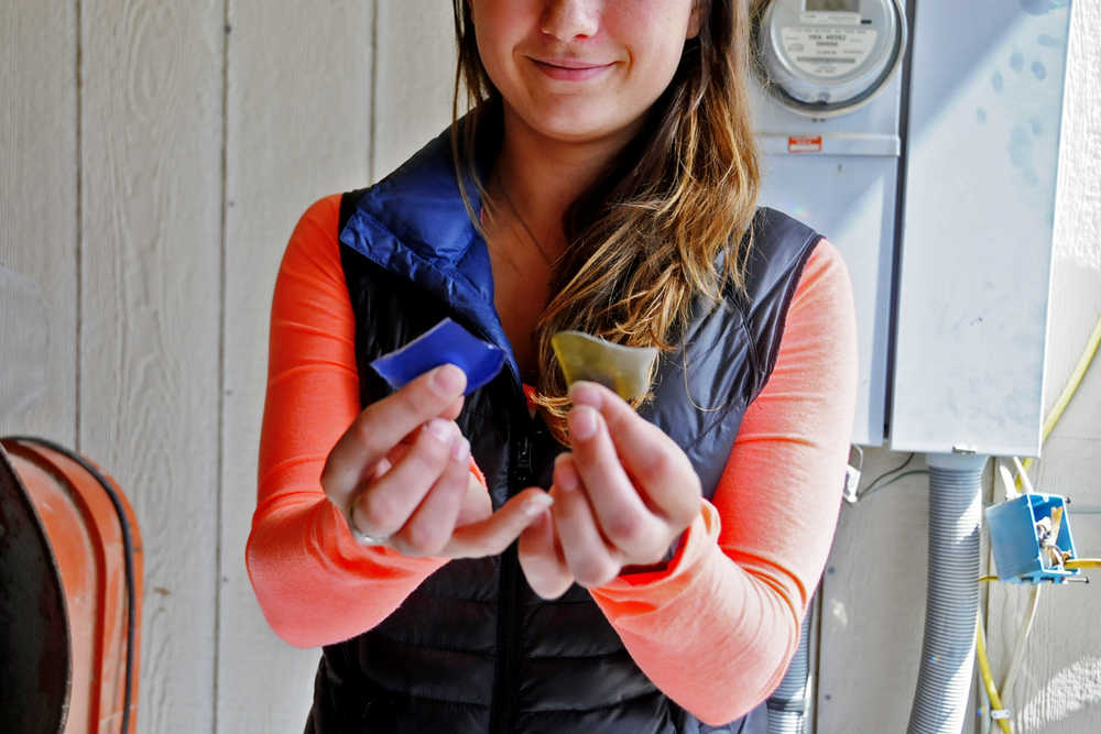 Photo by Elizabeth Earl/Peninsula Clarion Jenna Hansen shows the results of the cement mixer on recycled glass bottles at her home in Nikiski, Alaska on Wednesday, June 1, 2016. Hansen and her family turn recycled glass into handmade jewelry that they sell.