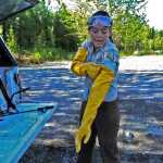 Photo by Elizabeth Earl/Peninsula Clarion Jen Peura, a seasonal biotech with the Kenai National Wildlife Refuge, pulls on the long gloves necessary to spray herbicides on invasive plants near the Egumen Lake trailhead on Tuesday, June 21, 2016.