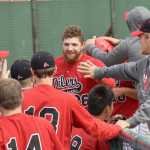 Photo by Jeff Helminiak/Peninsula Clarion Oilers Alex Seifert (26) and Ryan Smith (10) accept congratulations after scoring in the sixth inning to give the Oilers a 4-2 lead against the Chugiak Chinooks on Sunday at Coral Seymour Memorial Park in Kenai.