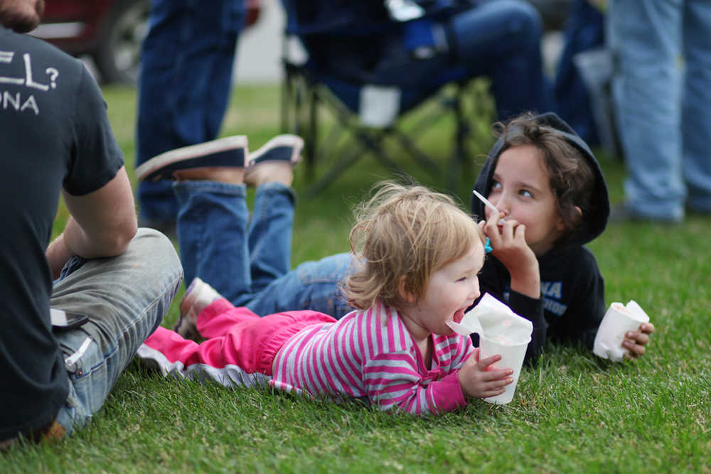 Photo by Kelly Sullivan/ Peninsula Clarion Shelby and Chevelle Gourley snack on snowcones during Kenai's July 4th festivities Monday, July 4, 2016 in Kenai, Alaska.