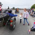 Photo by Kelly Sullivan/ Peninsula Clarion Kristin Freed and Addyon Carr rush to grab a handful of candy during Kenai's July 4th Parade on Monday, July 4, 2016 in Kenai, Alaska.