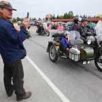 Photo by Kelly Sullivan/ Peninsula Clarion Alfred Port films the procession of antique cars in Kenai's Fourth of July Parade on Monday, July 4, 2016 in Kenai, Alaska.