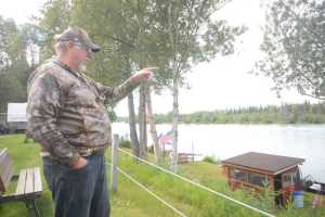 Photo by Megan Pacer/Peninsula Clarion Albera, Canada resident Doug Bangle, pictured Wednesday, July 13, 2016, points out the spot on the Kenai River where he and his son, Ryan, pulled out a 15-year-old girl who had fallen in early Tuesday morning. She was rescued when the men got into their boat after hearing her cries for help from their campsite at the Iva's Place RV Park on Knight Drive in Soldotna, Alaska.