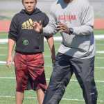 Photo by Jeff Helminiak/Peninsula Clarion Benni Collins of Eagle River listens as ex-NFL player George Teague instructs him on secondary play Friday at the Alaska All Star Football Camp at Kenai Central High School.