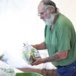Photo by Kelly Sullivan/ Peninsula Clarion Steve Dahl, volunteer coordinator for the central Kenai Peninsula Food Hub sales, divvies out ordered salad mix Tuesday, July 12, 2016, at Christ Lutheran Church in Soldotna, Alaska.