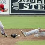 Photo by Jeff Helminiak/Peninsula Clarion Aaron Arruda of the Anchorage Bucs slides in safe after Oilers shortstop Trey Dawson lost his glove Sunday at Coral Seymour Memorial Park in Kenai.