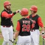 Photo by Jeff Helminiak/Peninsula Clarion Seth DeWitt is congratulated by Daniel Szpik and Jeffrey Chapuran after scoring on a double by Brody Wofford in the third inning Friday at a Top of the World Series semifinal at Coral Seymour Memorial Park in Kenai.