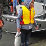 Photo by Elizabeth Earl/Peninsula Clarion Jezaniah Nelson, 8, of Anchorage, tries to get comfortable with holding her silver salmon through its gills at Centennial Campground's boat launch during the annual "Take Our Kids Fishing" event sponsored by the Boys & Girls Club and the Kenai River Foundation on Thursday, Aug. 11, 2016 in Soldotna, Alaska. The free event offers kids a chance to learn about the river and go out fishing with guides who volunteer their time.