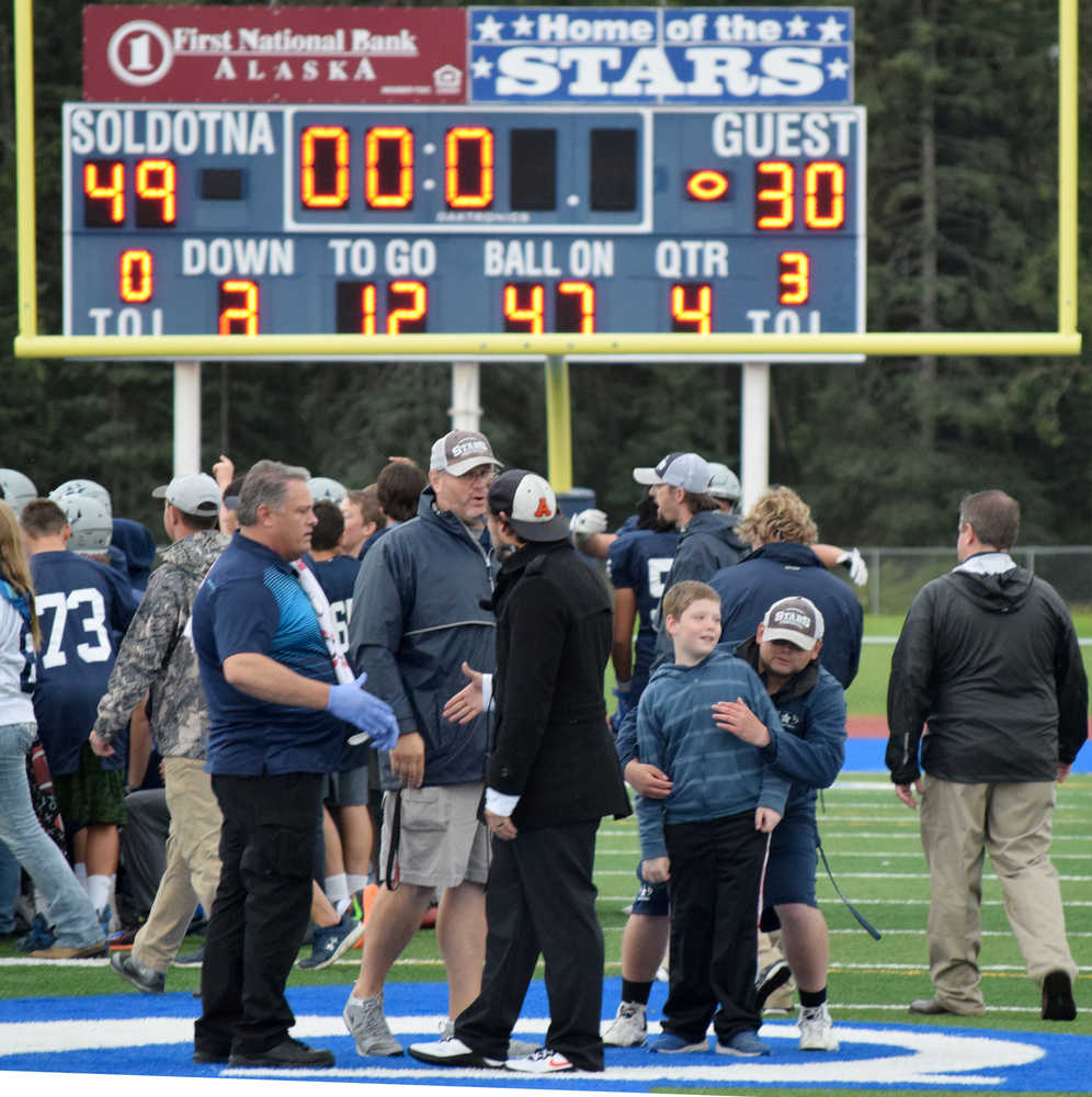 Photo by Jeff Helminiak/Peninsula Clarion Soldotna coach Galen Brantley Jr. and West coach Tim Davis meet at midfield following Soldotna's 49-30 victory over West on Friday at Justin Maile Field in Soldotna.