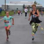 Ariana Cannava (left) races to beat Katrina Cannava at the finish of Saturday's Run for Women 5K race in Kenai.