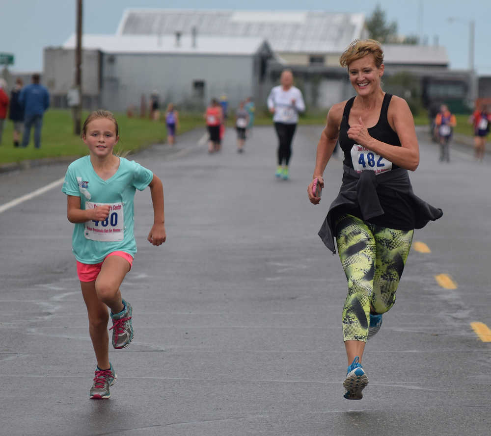 Ariana Cannava (left) races to beat Katrina Cannava at the finish of Saturday's Run for Women 5K race in Kenai.
