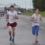 Photo by Joey Klecka/Peninsula Clarion Kyle McNally of Colorado (left) sprints to the finish line with Nikki Dixon in Saturday's Run for Women 10K race. McNally ran with Dixon in the race with the condition that he "dress" up for the event.
