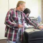 Photo by Megan Pacer/Peninsula Clarion Soldotna residents Tom Huff, foreground, and Hope Haselow, background, pick up stickers that read "I voted today" after turning in their ballots during the state primary election Tuesday, Aug. 16, 2016 at the Soldotna Regional Sports Complex in Soldotna, Alaska. Compared to last year, organizers said voter turnout at the complex was slow throughout the morning and early afternoon.
