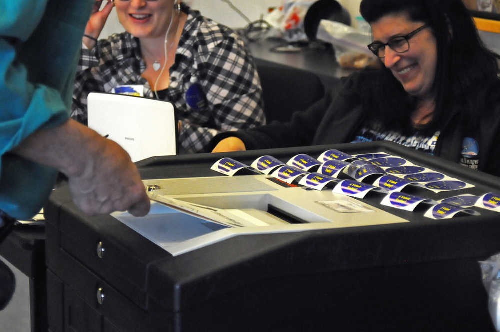 Photo by Elizabeth Earl/Peninsula Clarion Election workers chat with a voter as he files his ballot during the primary election Tuesday, Aug. 16, 2016 at Nikiski Fire Station 1 in Nikiski, Alaska.