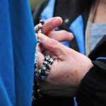 Photo by Elizabeth Earl/Peninsula Clarion A member of the Catholic Church holds her rosary as she prays near a Planned Parenthood clinic on Wednesday, Aug. 17, 2016 in Soldotna, Alaska. Members of the church gathered at the clinic before walking to the Kenai Peninsula Borough Administration Building to pray after a Satanic invocation was given to open the Aug. 9 borough assembly meeting.