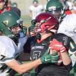 Photo by Jeff Helminiak/Peninsula Clarion Service's Jalen Dunlap tries unsuccessfully to pry the ball from Kenai Central's Avery Heiber on a kickoff return Friday at Ed Hollier Field in Kenai.