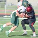 Photo by Jeff Helminiak/Peninsula Clarion Kenai Central's Nick Beeson wraps up Service's Conner O'Farrell for a loss Friday at Ed Hollier Field in Kenai.