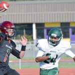 Photo by Jeff Helminiak/Peninsula Clarion Kenai Central quarterback Chase Gillies passes under pressure from Service's Dominik Norman on Friday at Ed Hollier Field in Kenai.