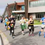 Racers run past the Kenaitze Indian Tribe's Dena'ina Wellness Center at the start of the CASA Superhero 5-kilometer run/walk on Saturday morning. The event raised funds for the tribe's Court Appointed Special Advocates program.