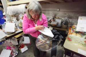 Photo by Kelly Sullivan/ Peninsula Clarion Kenai Peninsula Food Bank Executive Director Linda Swarner searches through this year's donations for the  20th annual Soup Supper on Monday, Aug. 15, 2016 at the Kenai Peninsula Food Bank in Soldotna, Alaska.