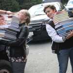 Photo courtesy Joe Rizzo Savannah Rizzo and Sarah Nash carry piles of books into Hope School.